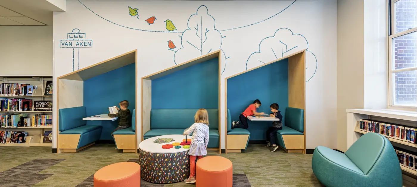 The childrens section of the library with kids reading and playing